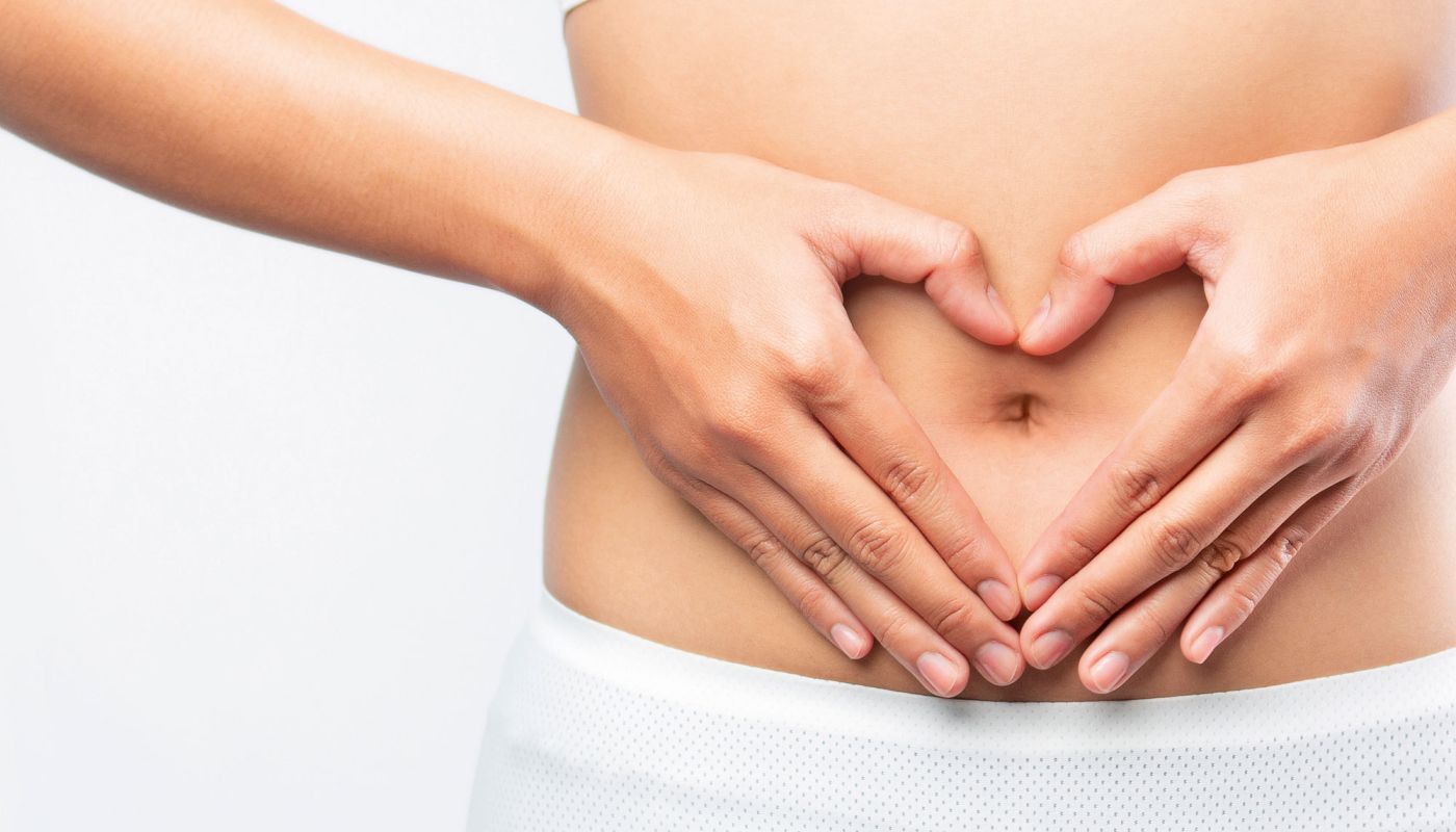 Person formt Herzsymbol mit den Händen vor dem Bauch