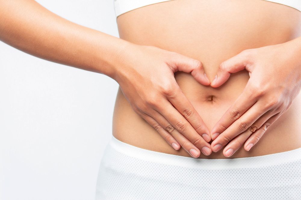 Person formt Herzsymbol mit den Händen vor dem Bauch