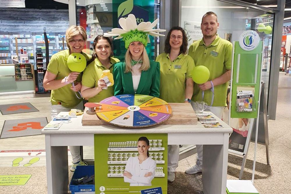 Apothekenteam mit grünen Shirts bei Aktionstag am Stand