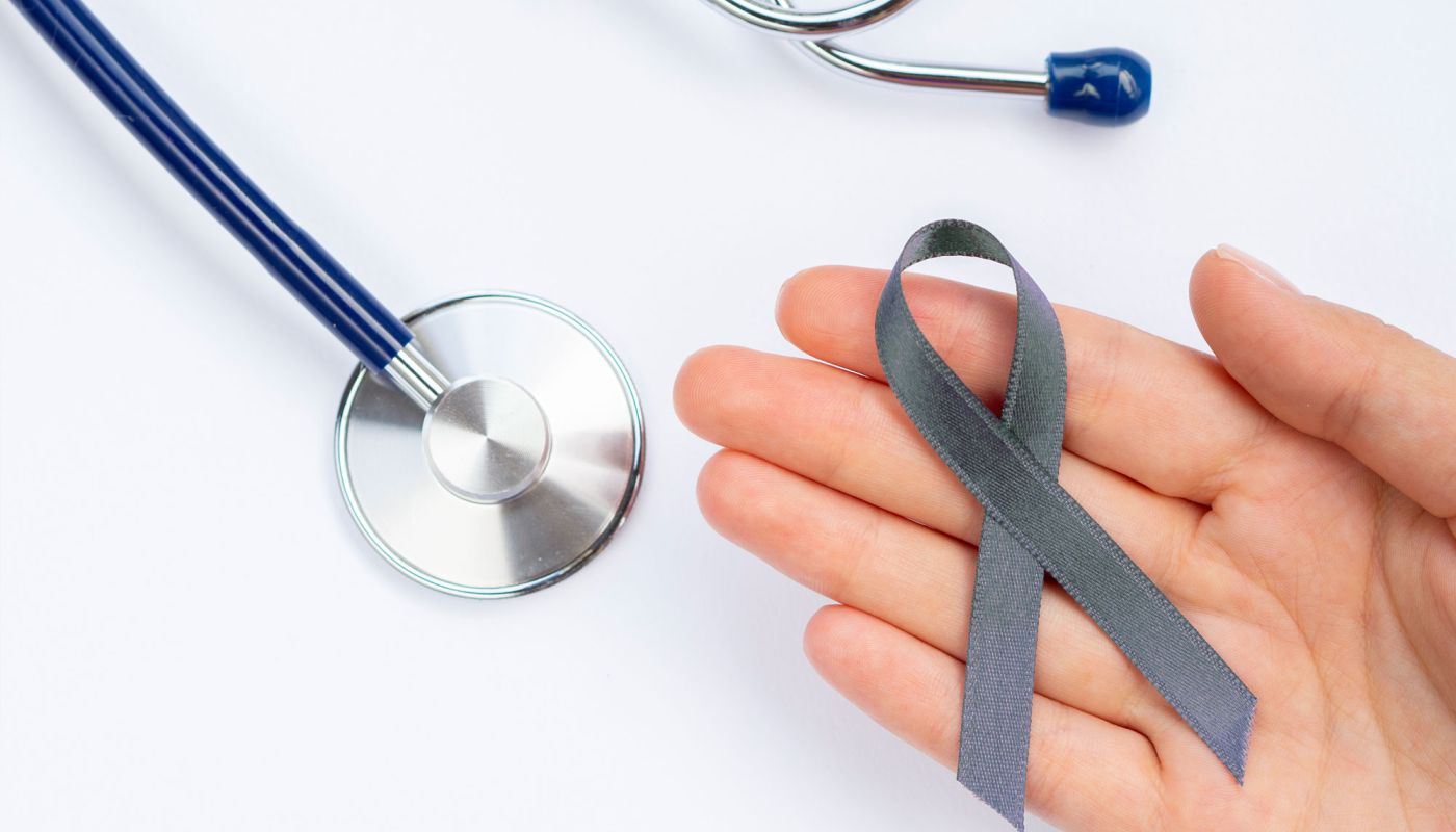 Stethoskop neben grauer Schleife auf weißem Untergrund