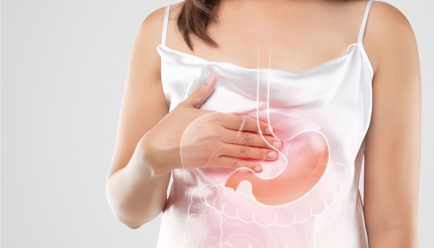 Frau hält sich die Brust, grafische Einblendung von Magen und Speiseröhre