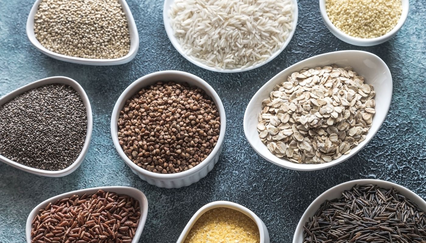 Verschiedene Getreidesorten wie Reis, Hafer und Quinoa in Schalen
