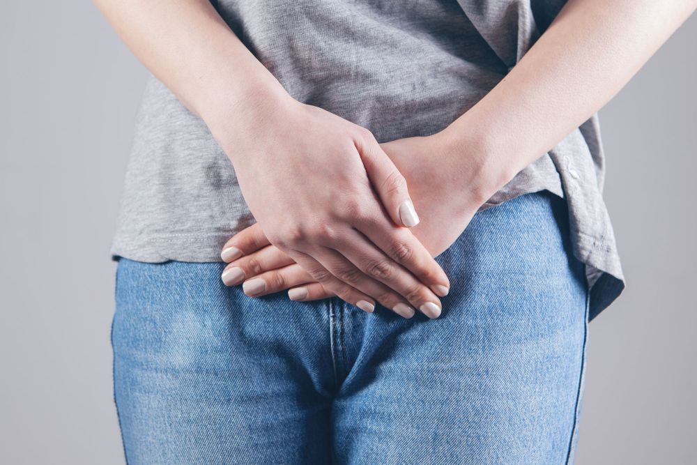 Frau hält sich schmerzhaft den Unterbauch