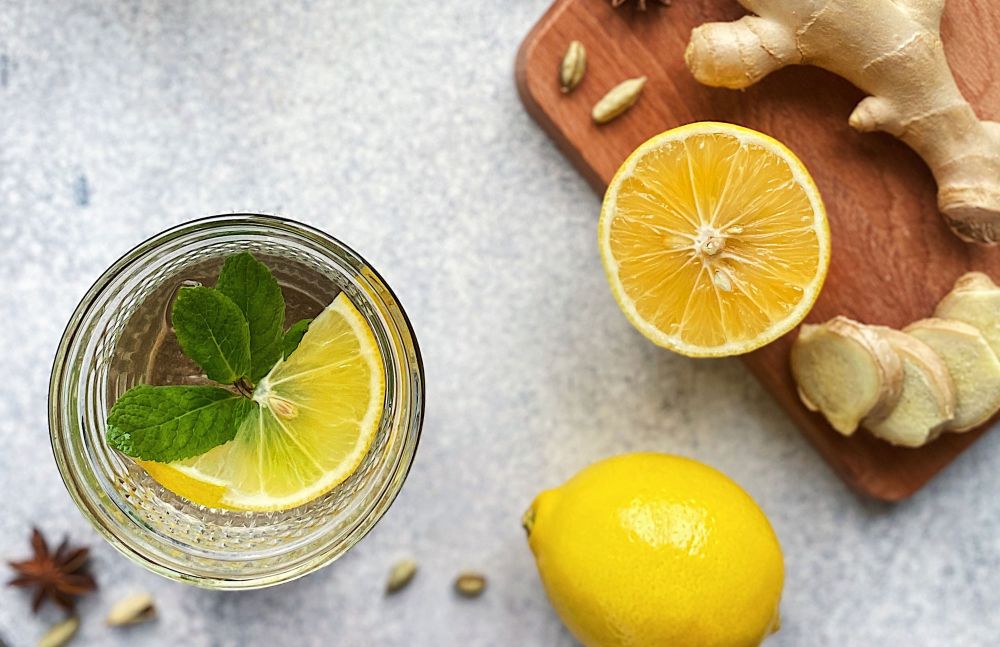 Heißgetränk mit Zitrone, Minze und Gewürzen auf Holztisch