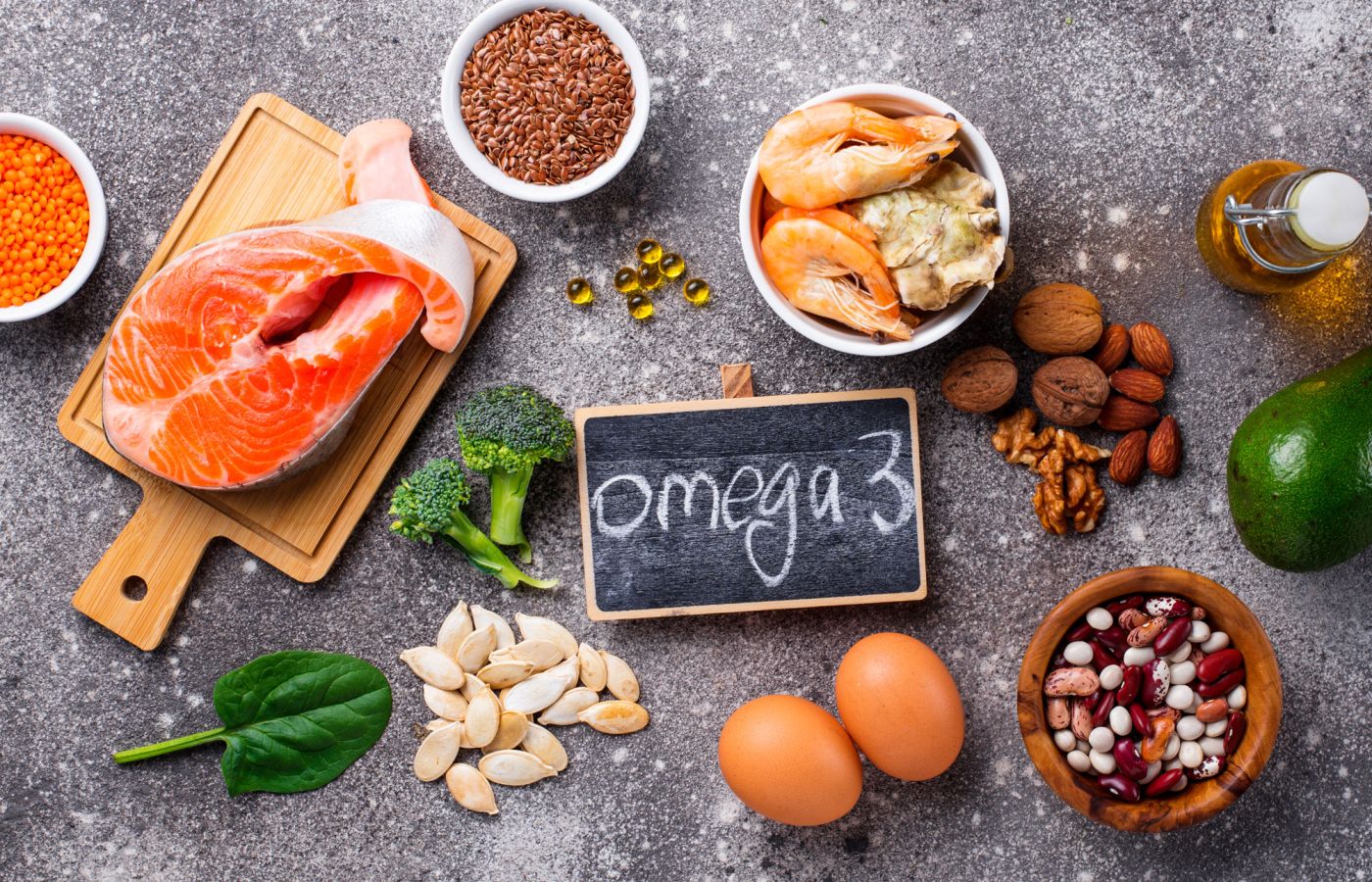 Lebensmittel wie Lachs, Nüsse und Samen mit Tafelaufschrift Omega 3