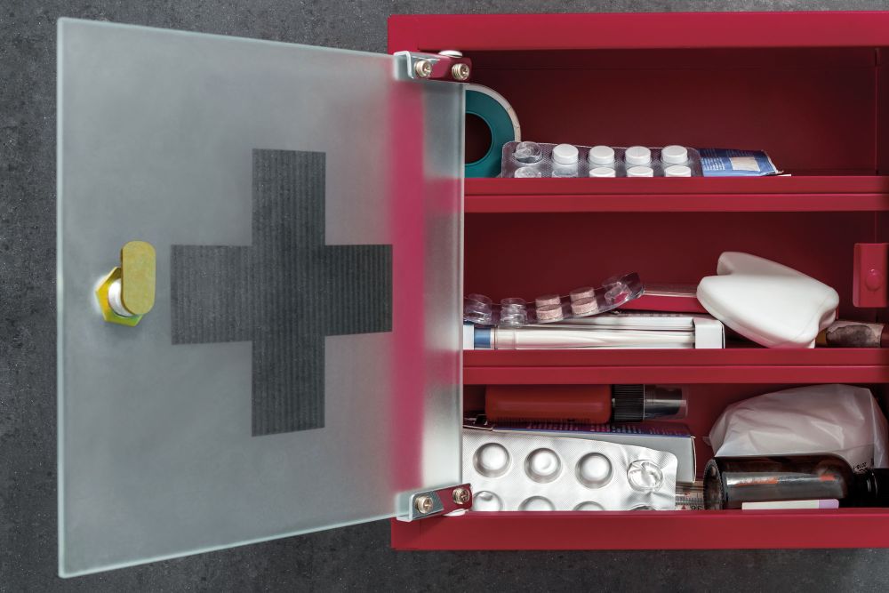 Geöffnete rote Hausapotheke mit Medikamenten und Verbandsmaterial