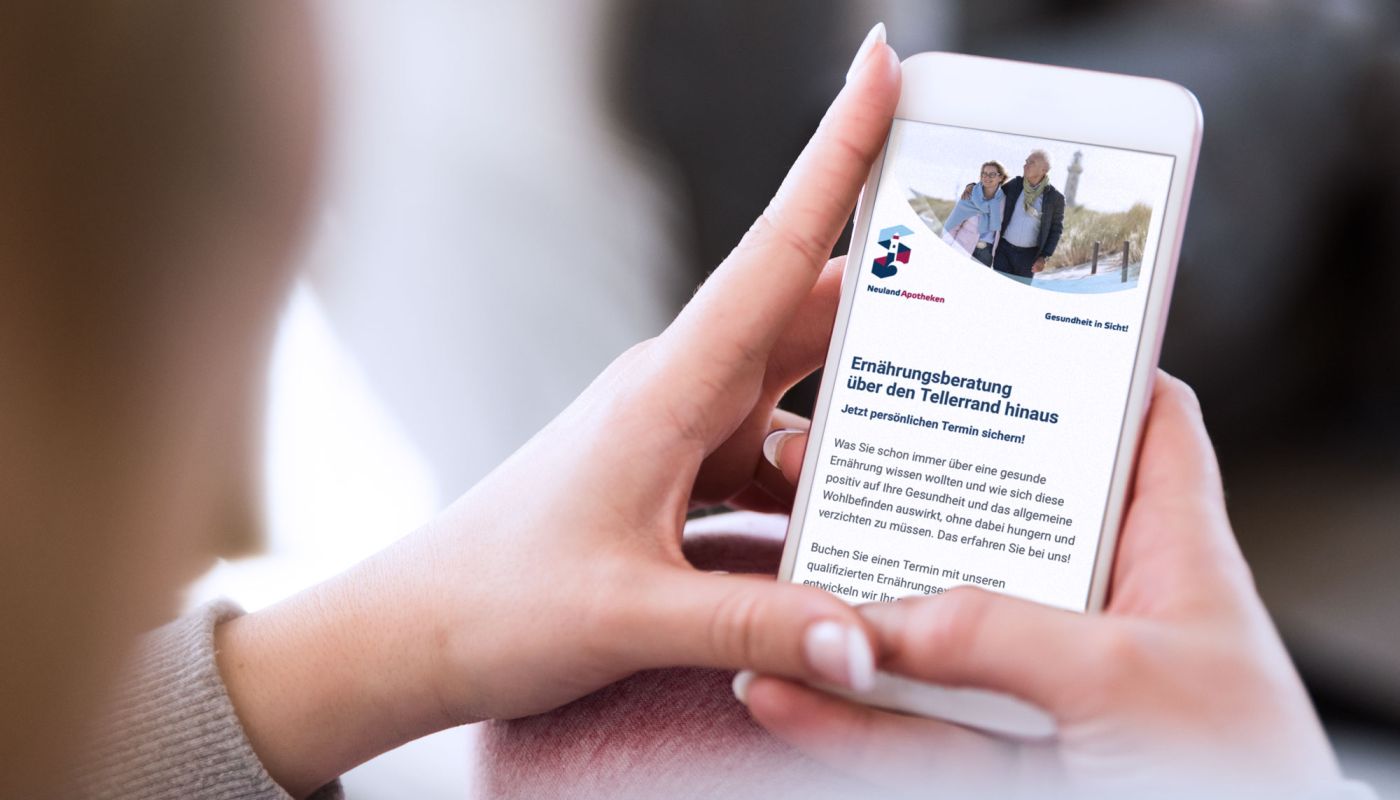 Hand hält Smartphone mit Newsletter der Neuland Apotheken