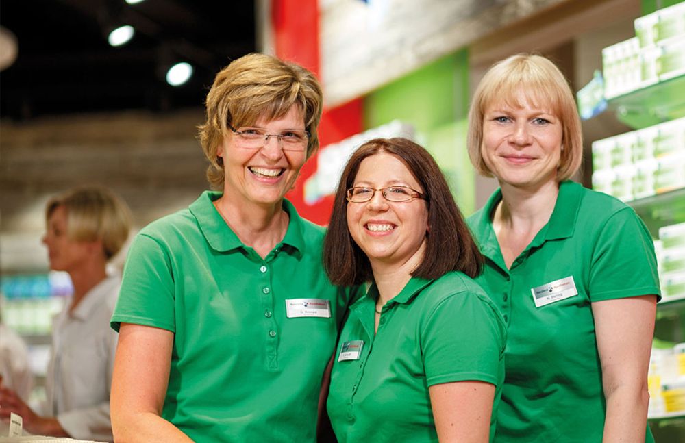 Drei Mitarbeiterinnen der Apotheke in grünen Poloshirts