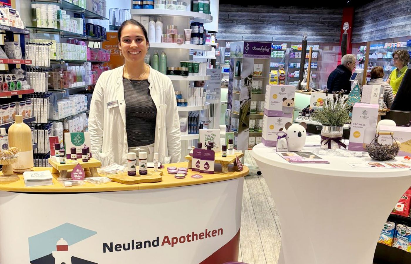 Apothekerin am Beratungstisch mit ätherischen Ölen in der Neuland Apotheke