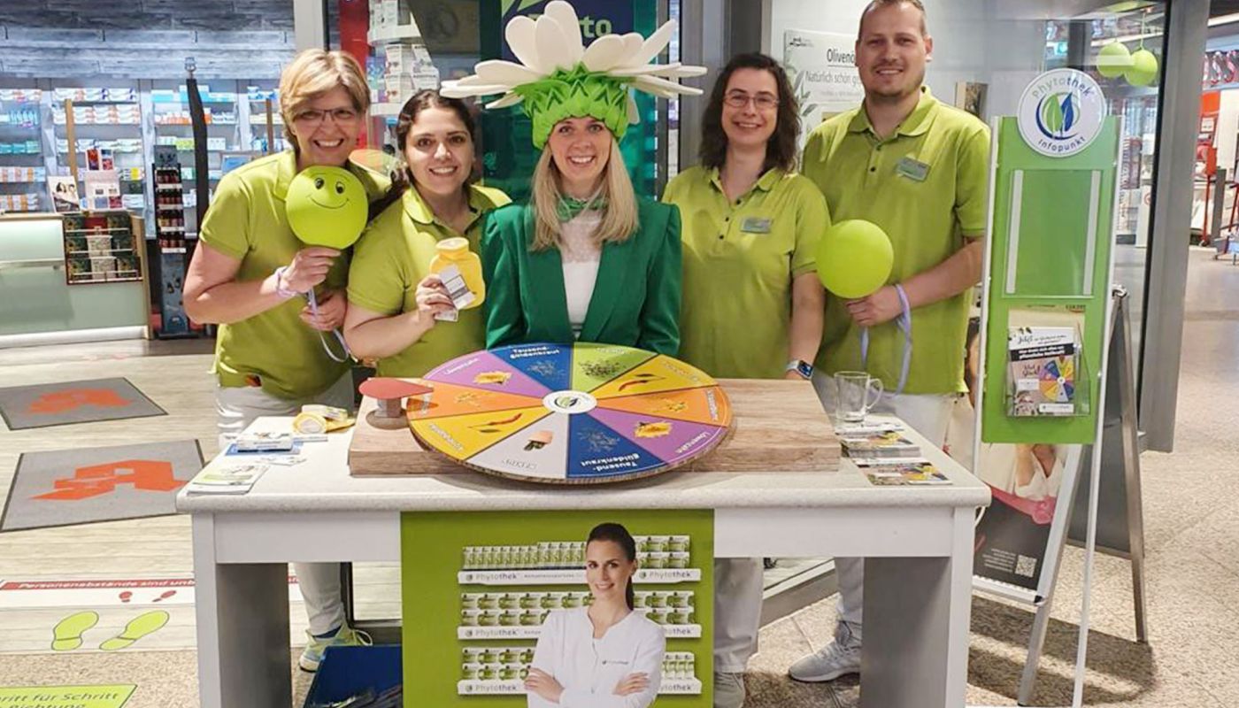 Apothekenteam mit grünen Shirts bei Aktionstag am Stand