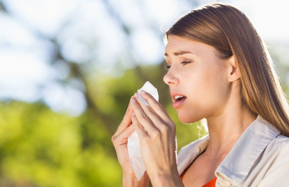 Mensch niest im Freien während Pollen fliegen