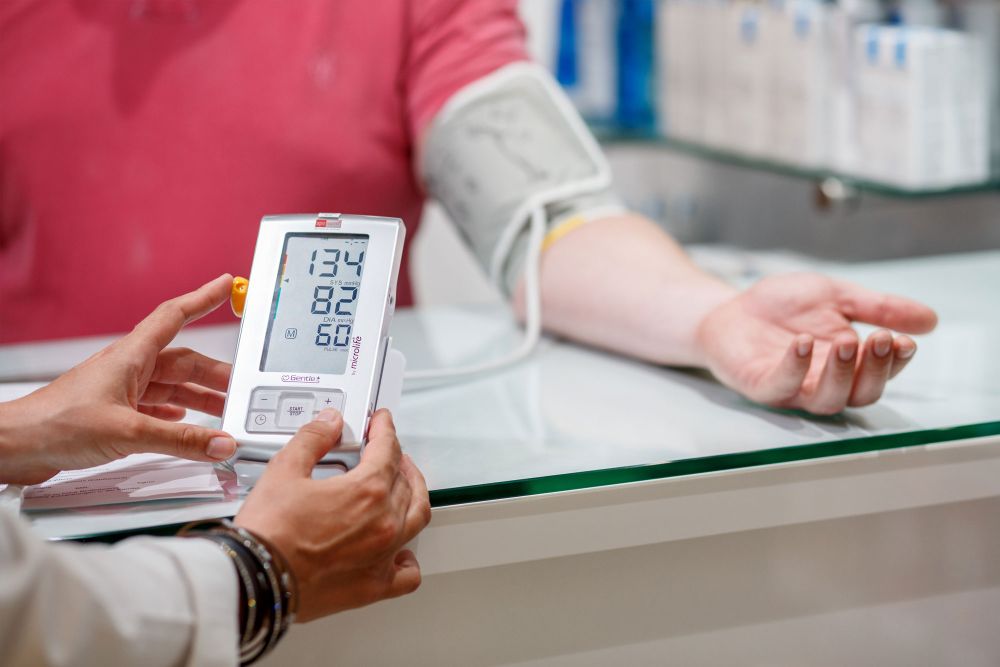 Blutdruckmessgerät zeigt Werte, Apothekerin erklärt Messung