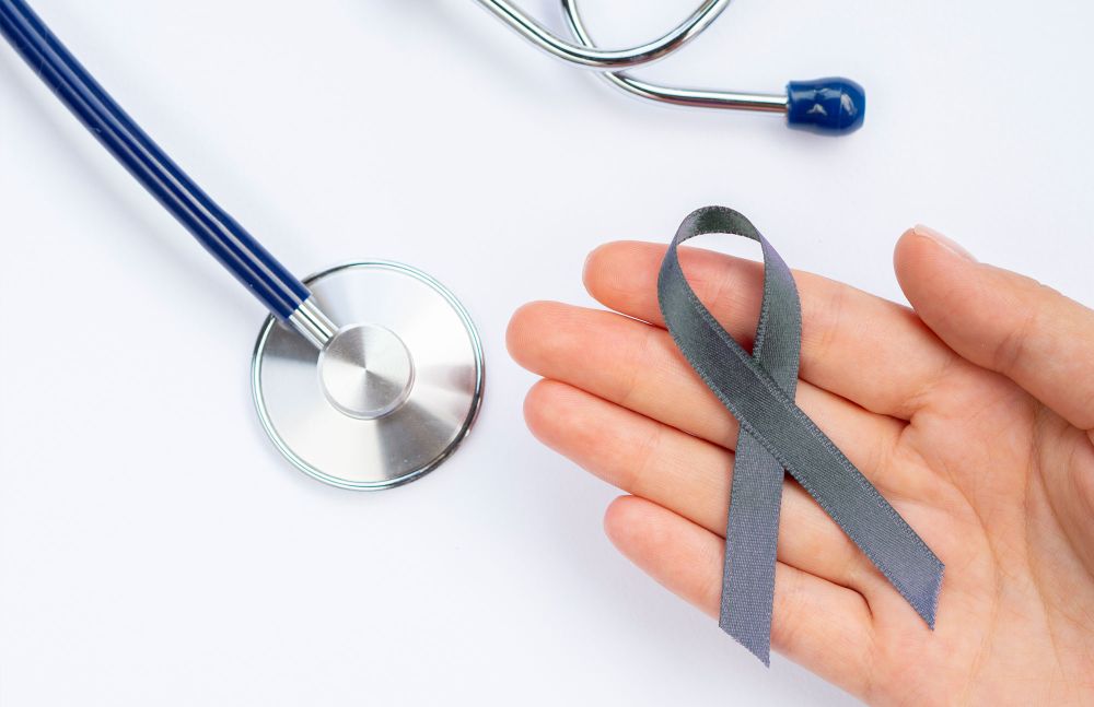 Stethoskop neben grauer Schleife auf weißem Untergrund