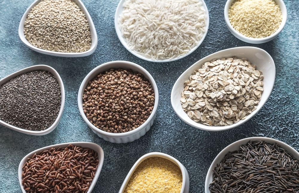 Verschiedene Getreidesorten wie Reis, Hafer und Quinoa in Schalen