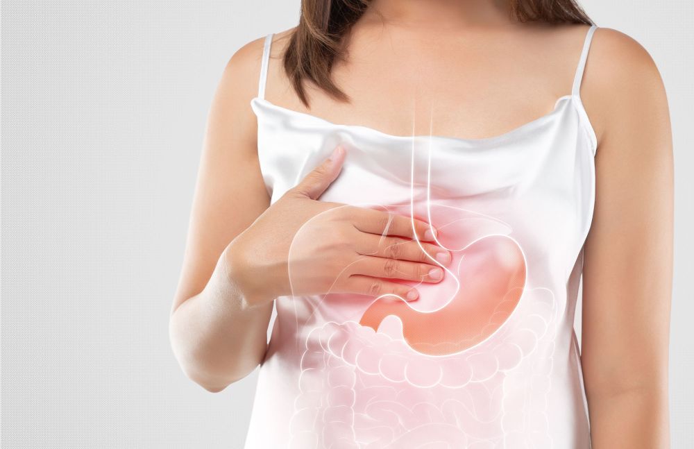 Frau hält sich die Brust, grafische Einblendung von Magen und Speiseröhre