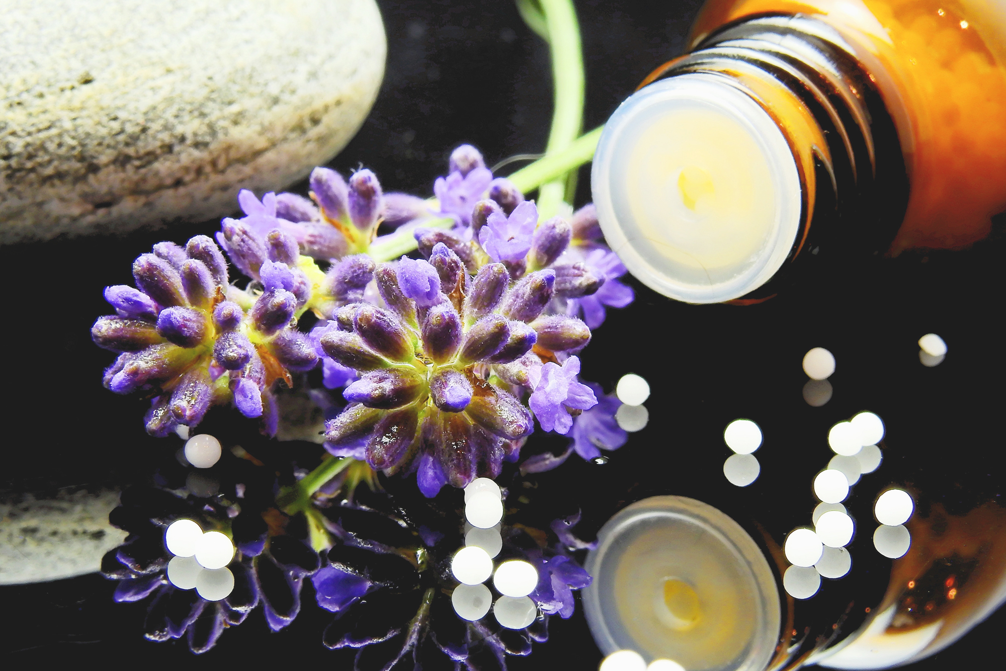 Braunes Fläschchen mit Lavendelblüten und Globuli