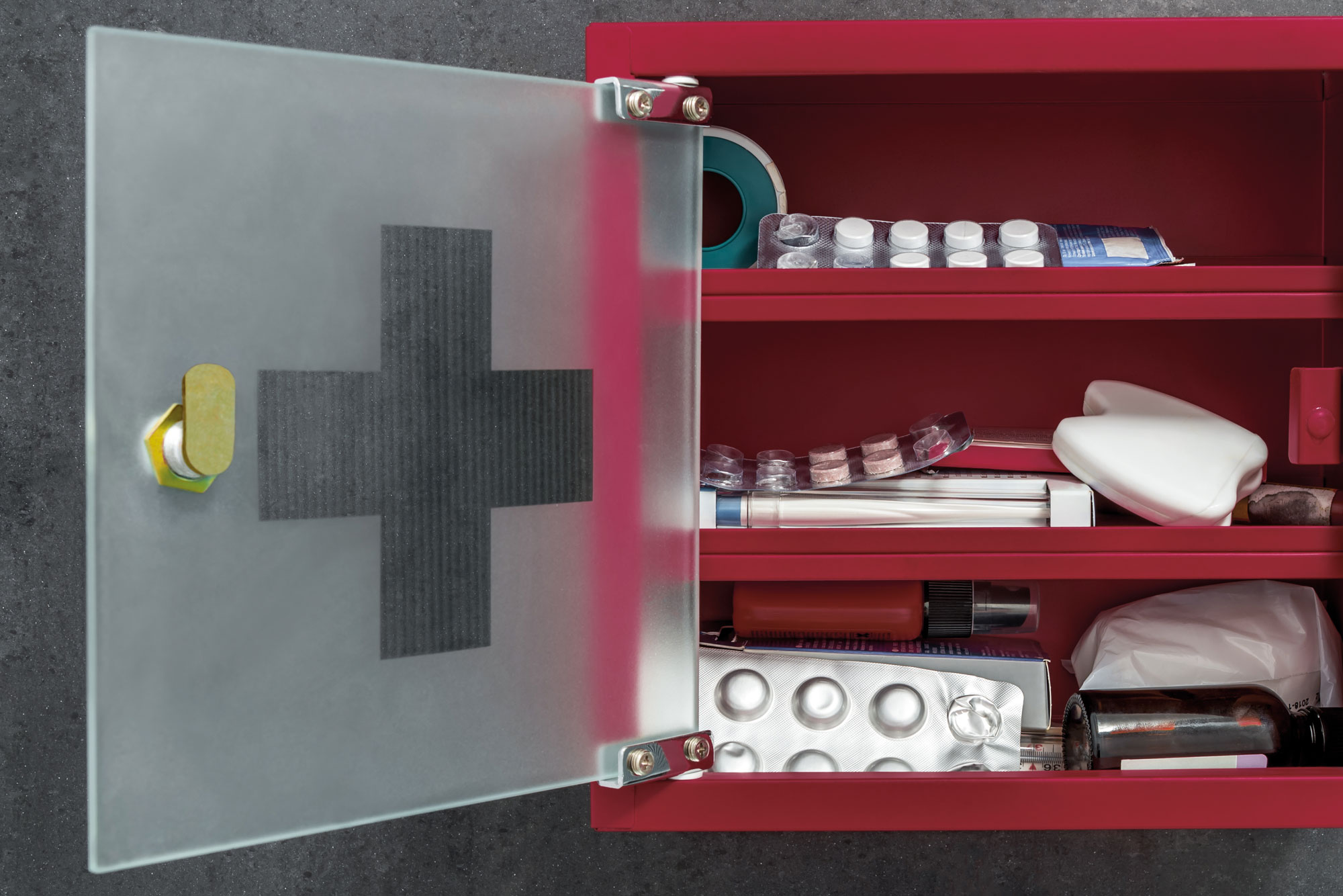 Geöffnete rote Hausapotheke mit Medikamenten und Verbandsmaterial