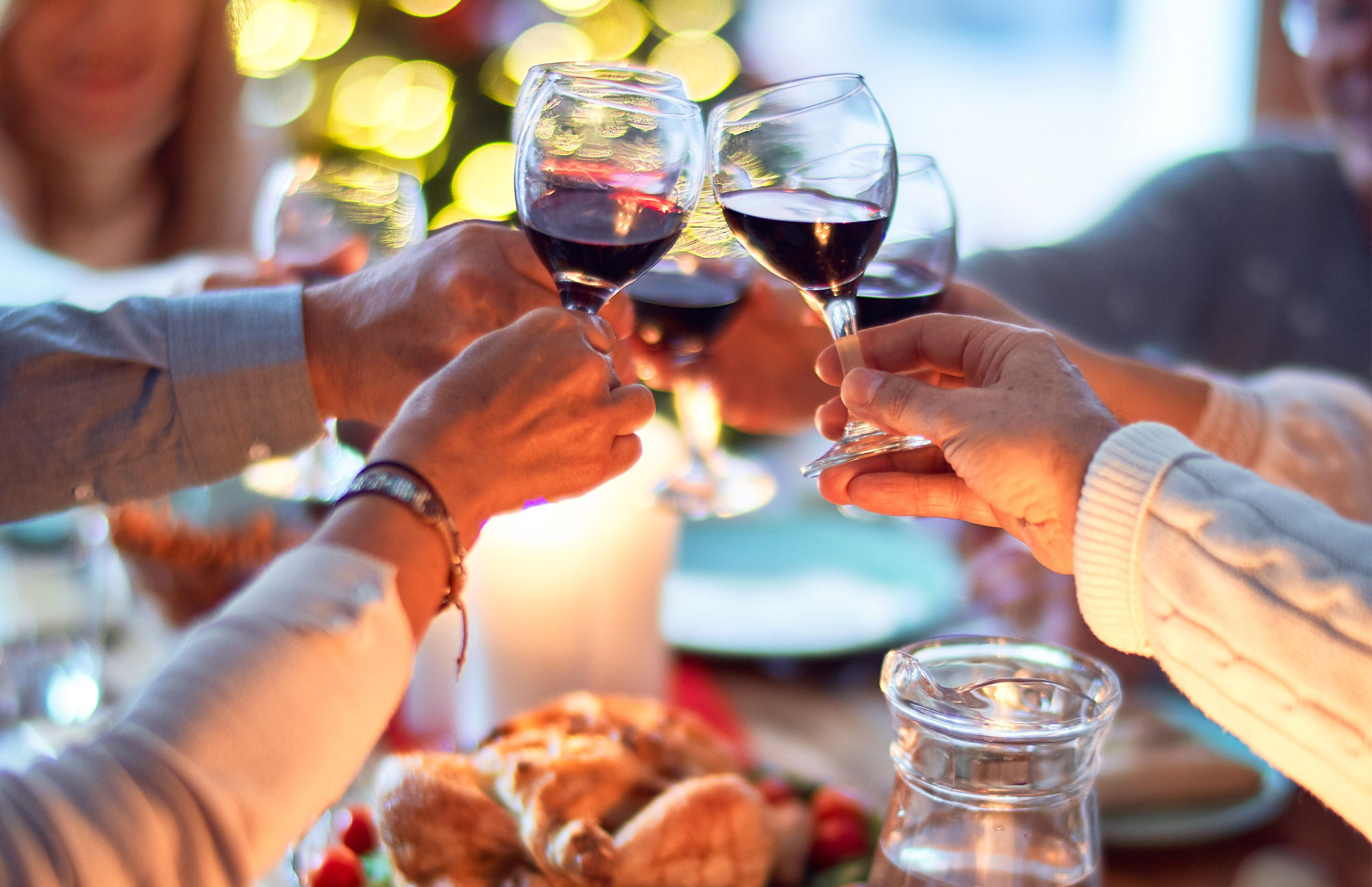 Mehrere Personen stoßen beim Abendessen mit Rotwein an